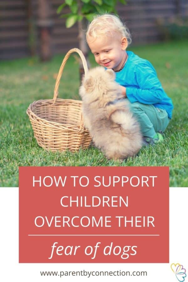 a young child is smiling and sitting next to a puppy in a post about ways to support children overcome their fear of dogs